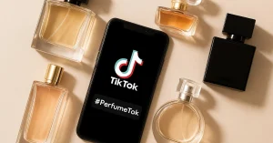 Home Trending PerfumeTok fragrances arranged around a smartphone displaying the viral #PerfumeTok hashtag on TikTok
